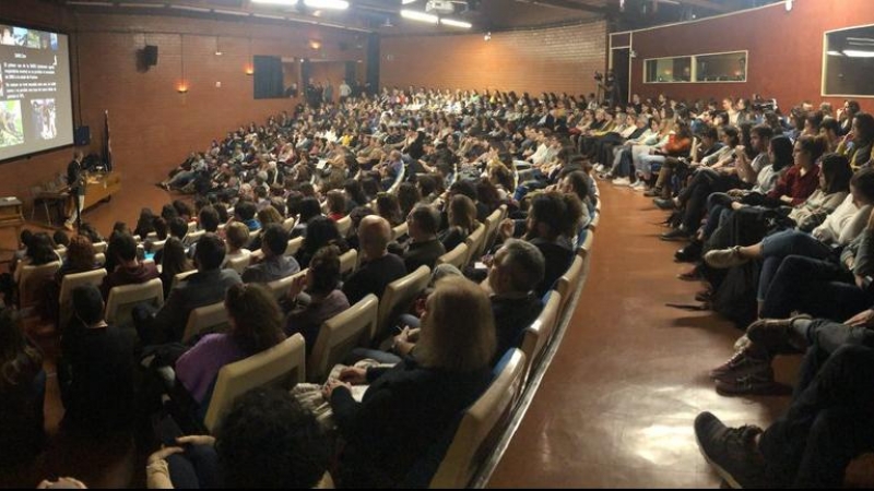 Una imatge de l'Aula Magna de la Facultat de Biologia de la UB plena de gom a gom en l'acte sobre el coronavirus. @GeneticsUB