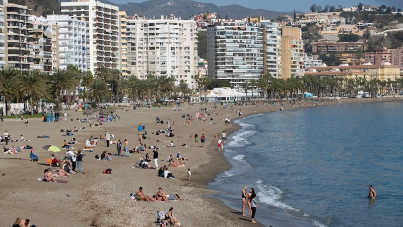 Varias personas toman el sol en la playa de La Malagueta. EFE