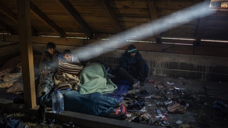 Migrantes afganos se despiertan en el interior de una cabaña que utilizan para dormir durante su travesía por las montañas de Bosnia para cruzar la frontera. JM López.