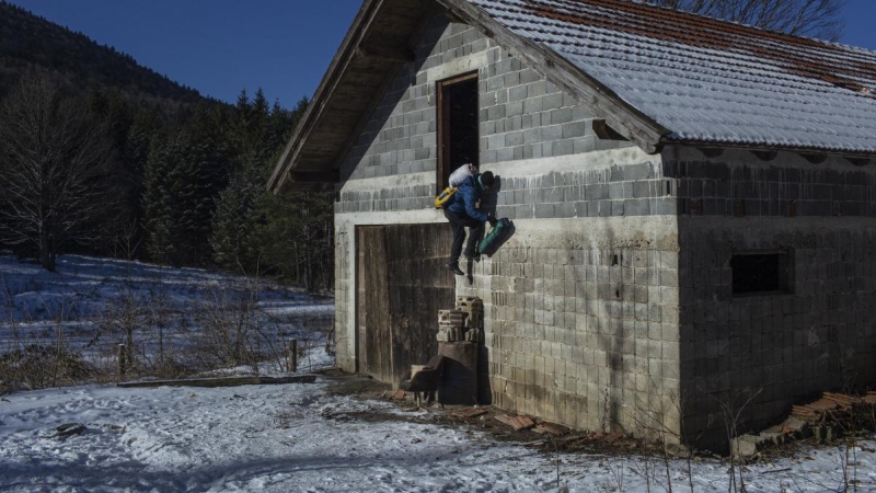 Un migrante afgano sale de una cabaña que utiliza para dormir durante su travesía por las montañas de Bosnia para cruzar la frontera. JM López.