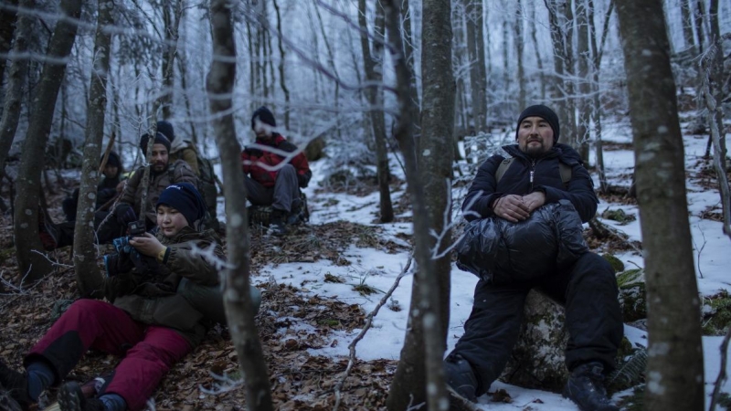 Ehsan descansa junto a su padre, Hossein, durante su travesía por el bosque en dirección a la frontera con Croacia. JM López.