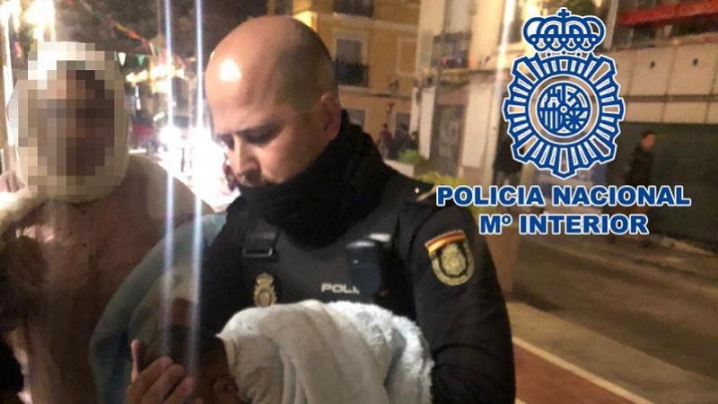 El agente que salvó la vida del bebé, con el menor en brazos./ Policía Nacional