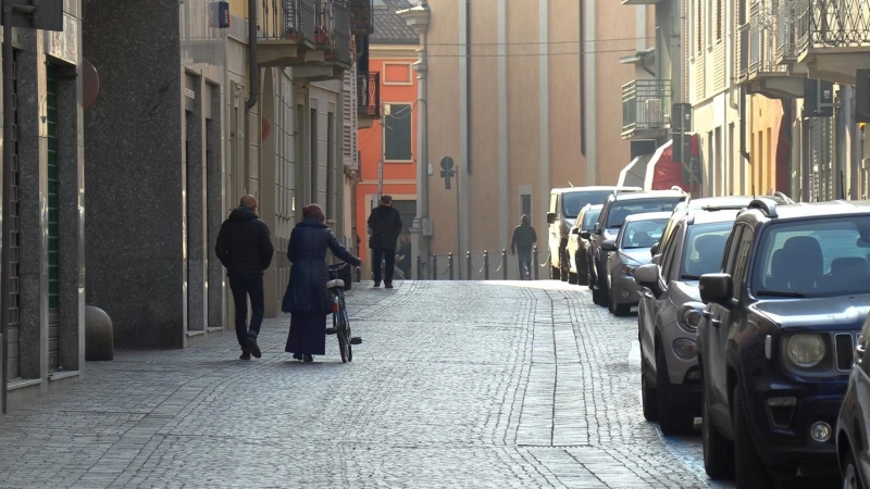 Gente paseando por una calle vacía en el pueblo de Codogno después de que las autoridades pidieran que se quedaran en casa y suspendieran las actividades públicas. / REUTERS