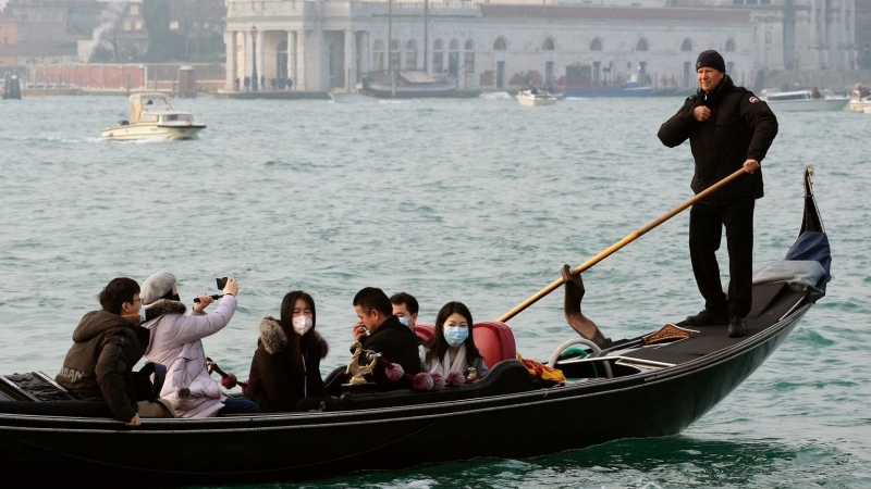 Unos pasajeros en góndola por Venecia portan mascarillas mientras dan un paseo. REUTERS/Manuel Silvestri