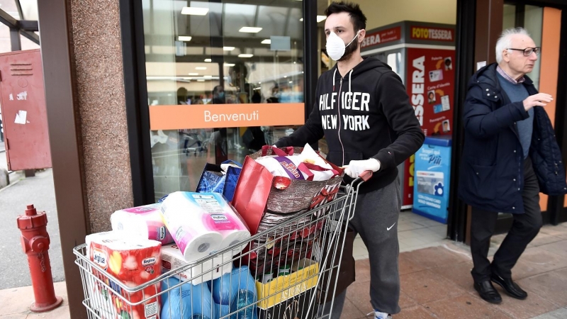 Un hombre hace acopio de enseres de primera necesidad en un supermercado italiano. REUTERS/Flavio Lo Scalzo