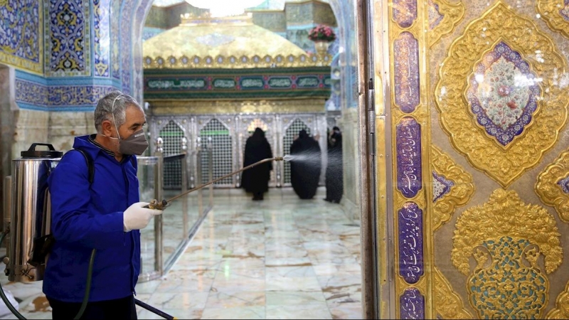 Un miembro del personal desinfecta el Santuario Masumeh en la ciudad de Qom, Irán. - EFE