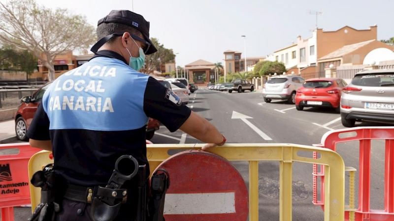 Un agente de policía coloca una valla para prohibir el paso al hotel situado en el municipio tinerfeño de Adeje. - EFE
