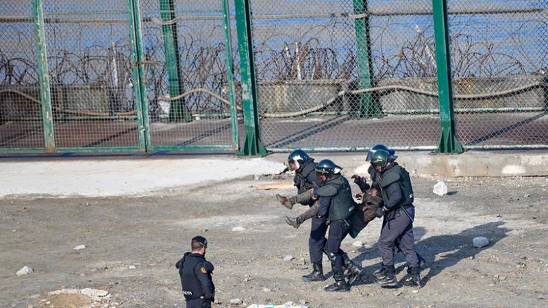 La guardia civil traslada a la fuerza a un migrante para su devolución en caliente a Marruecos tras saltar la valla de Ceuta el 30 de agosto de 2019.- CEAR/José Antonio Sempere