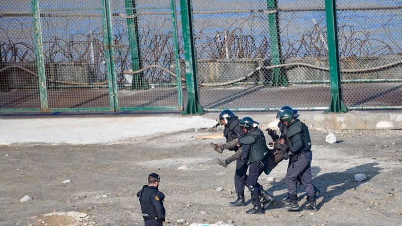 La guardia civil traslada a la fuerza a un migrante para su devolución en caliente a Marruecos tras saltar la valla de Ceuta el 30 de agosto de 2019.- CEAR/José Antonio Sempere