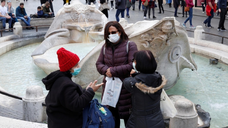 Turistas con máscaras protectoras descansan junto a la fuente de Barcaccia en Roma, Italia. REUTERS / Remo Casilli