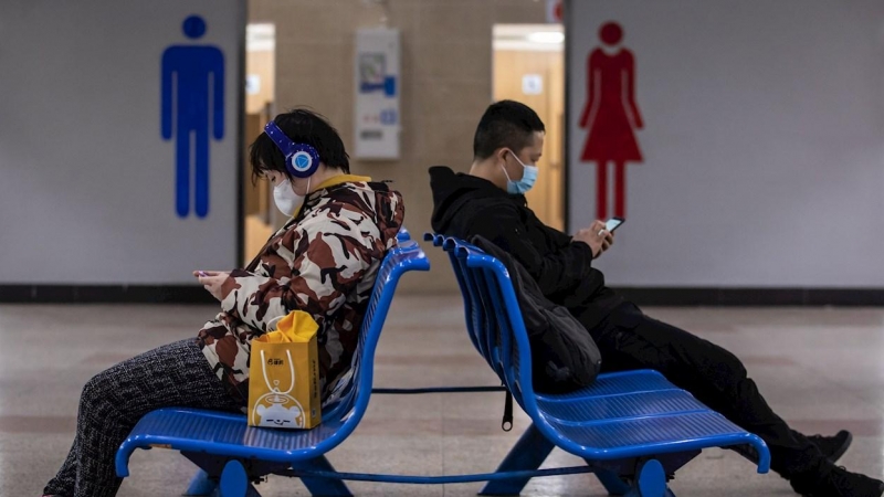 Dos personas con mascarilla en una estación de tren en Shanghai. - EFE