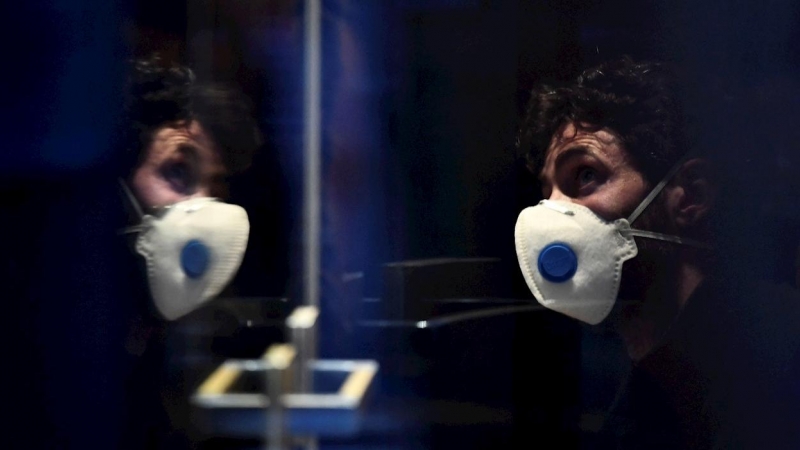 un hombre con mascarilla en un hotel en Innsbruck, Austria, donde una mujer ha dado positivo en coronavirus. - EFE