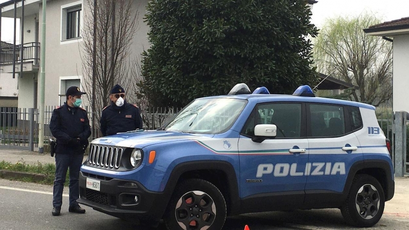 Dos operarios de la Policía Local italiana hacen guardia este martes en uno de los puestos de control para entrar en un municipio en cuarentena en la 'zona roja' de Lombardía, a 45 kilómetros de Milán. - EFE