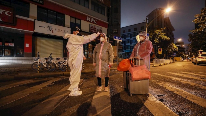 Un voluntario toma la temperatura a una mujer embaraza en la ciudad china de Wuhan. - EFE