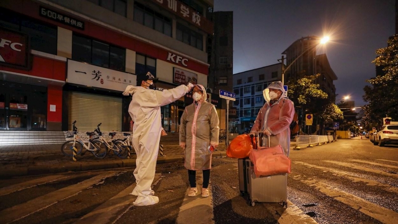 Un voluntario toma la temperatura a una mujer embaraza en la ciudad china de Wuhan. - EFE