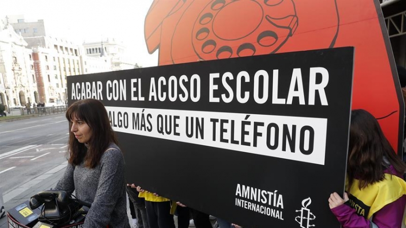 GRAF8275. MADRID, 28/02/2020.- Jóvenes activistas de Amnistía Internacional despliegan un teléfono de disco gigante en la puerta principal del Ministerio de Educación este viernes en Madrid para denunciar que el actual sistema de denuncias de acoso escola