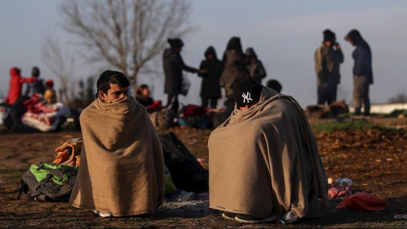 Dos personas se protegen del frío en Edirne, cerca del río Evros. - EFE