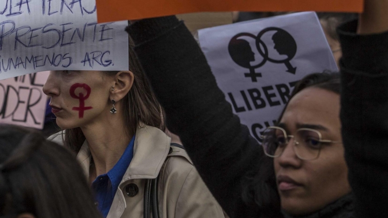 Asistentes a la manifestación feminista de Madrid lucen carteles con nombres de mujeres víctimas de la violencia machista. JAIRO VARGAS