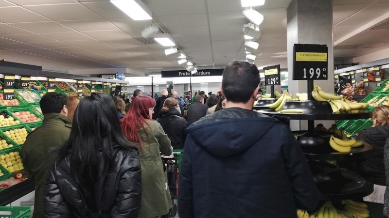 Decenas de personas esperan a pagar su compra en un supermercado en Madrid. EFE/Juan Vargas