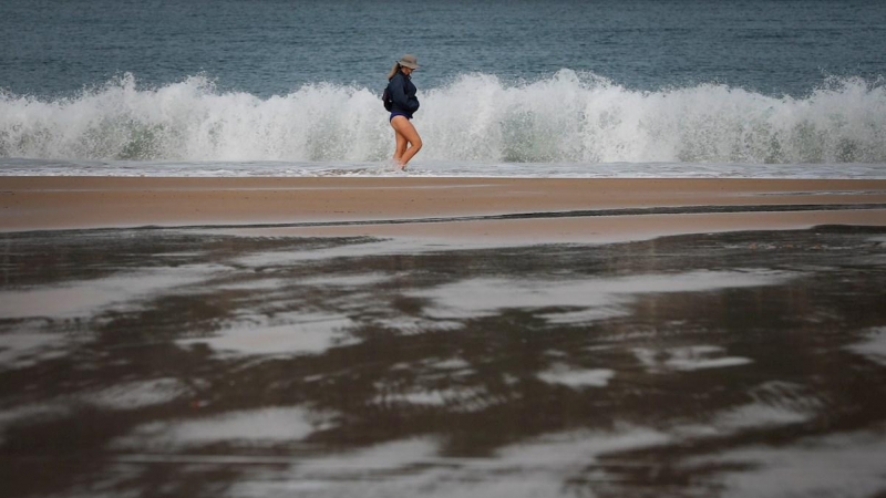 Una mujer pasea este martes por la orilla de la playa de La Concha de San Sebastián. EFE