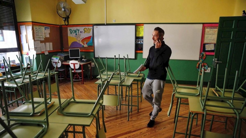 Un docente habla por su teléfono móvil en un aula desierta en un colegio público de Madrid.. - EFE