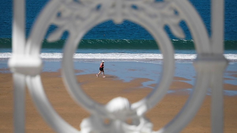 11/03/2020.- Una mujer pasea este miércoles por la orilla de la playa de La Concha de San Sebastián. / EFE - JAVIER ETXERARRETA