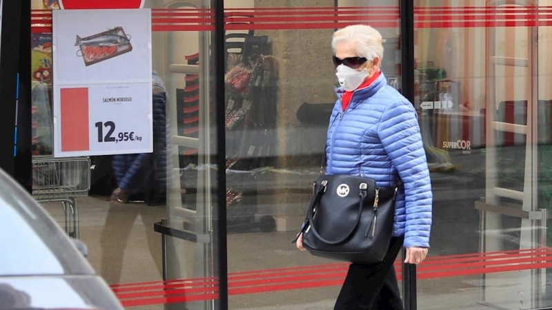 Una mujer protegida con mascarilla pasa delante de un supermercado en Madrid. EFE/ Fernando Alvarado