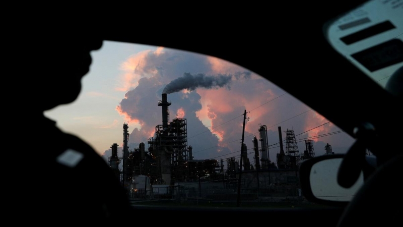Desde su coche, un policía ve el humo de una refinería industrial de Texas. Reuters/Loren Elliott