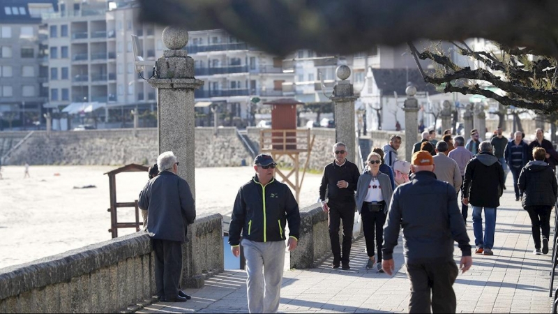 Turistas en el paseo marítimo de Silgar, en la playa de Xanxenxo, que ha recibido estos días a cientos de madrileños. /EFE