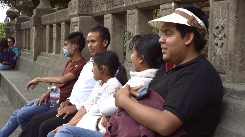 Una familia mexicana sentada junto a un monumento. | Anna Portella