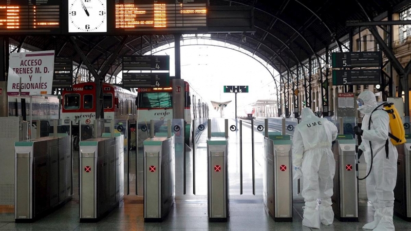 Miembros de la Unidad Militar de Emergencia (UME) trabajan en la estación de Renfe y de autobuses de València para desinfectar dichos lugares. De fondo, un andén desierto./ Manuel Bruque (EFE)