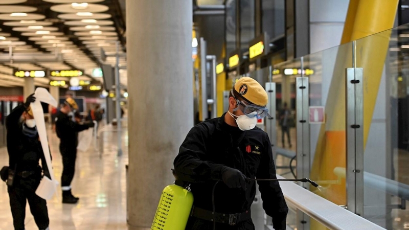 Efectivos de la UME durante las labores de desinfección, este jueves, en la T-4 del Aeropuerto de Madrid-Barajas durante la cuarta jornada laboral de aislamiento para frenar el avance del coronavirus. EFE/Fernando Villar