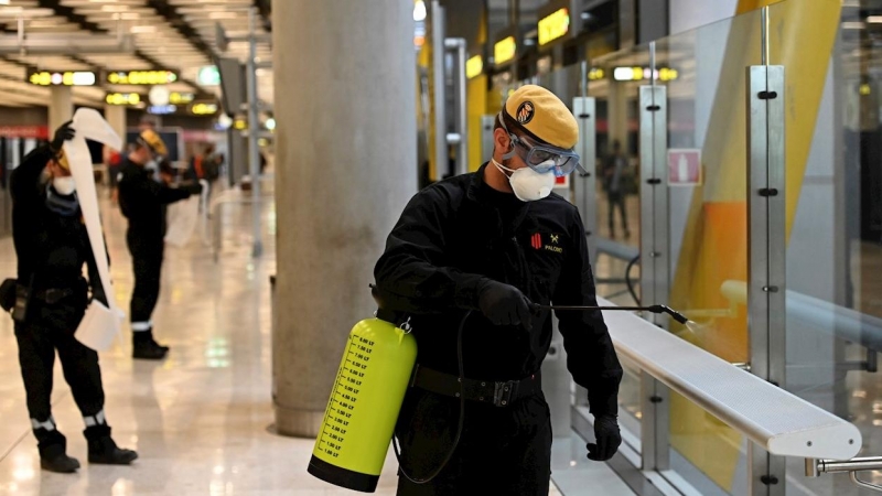 Efectivos de la UME durante las labores de desinfección, este jueves, en la T-4 del Aeropuerto de Madrid-Barajas durante la cuarta jornada laboral de aislamiento para frenar el avance del coronavirus. EFE/Fernando Villar