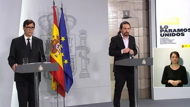 Captura de la señal institucional del Palcio de la Moncloa.- El vicepresidente de Asuntos Sociales y Agenda 2030, Pablo Iglesias (d), este jueves durante la rueda de prensa en el Palacio de la Moncloa, en la que ha comparecido junto al ministro de Sanida