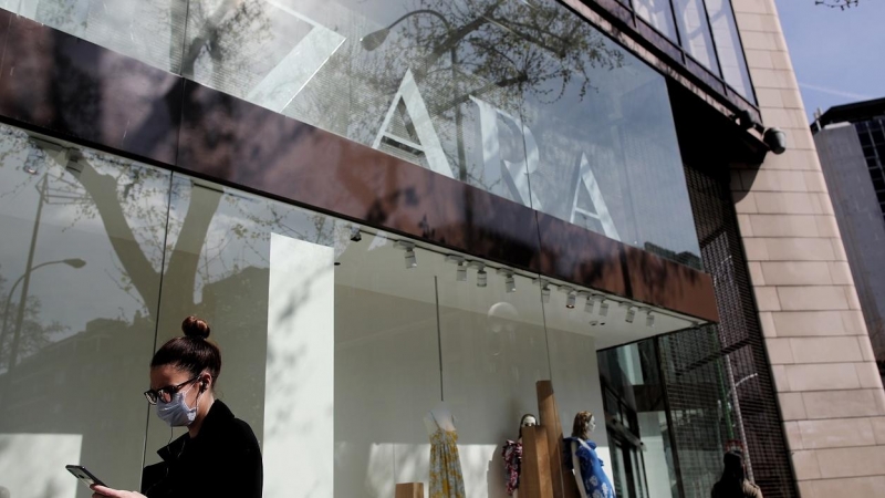 Una mujer con mascarilla pasa junto al escaparate de la tienda Zara, la principal enseña de Inditex, en Madrid. E.P./Eduardo Parra