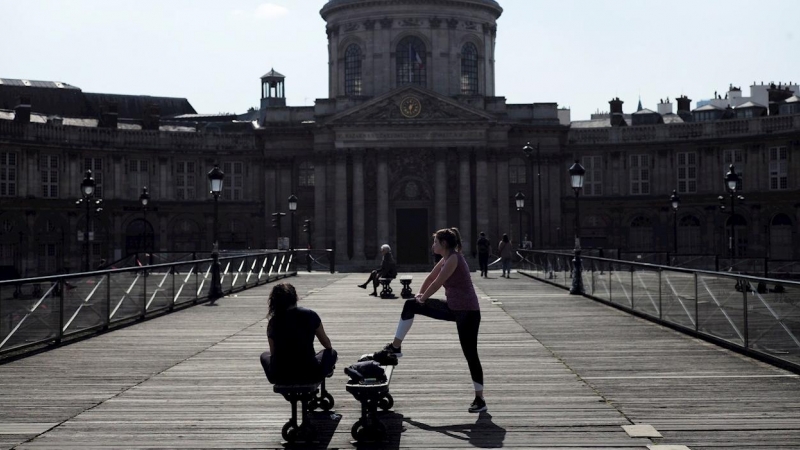 19/03/2020.- Mujeres hacen ejercicio en el Puente de las Artes de París (Francia) pese a las limitaciones de libertad de movimiento por el coronavirus. / EFE - JULIEN DE ROSA