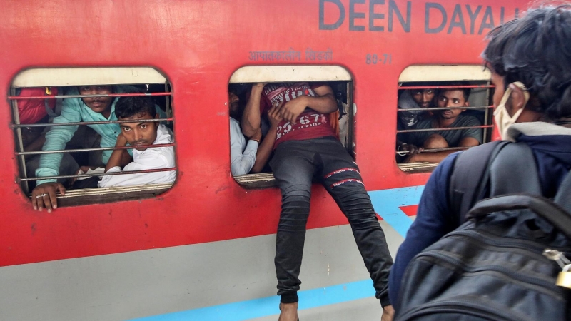 Un trabajador migrante intenta coger el tren en Mumbai, India. REUTERS / Prashant Waydande