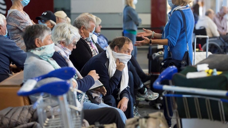 Varios pasajeros con mascarilla esperan su vuelo en las instalaciones del Aeropuerto de Málaga durante la octava jornada de confinamiento tras decretarse el Estado de Alarma por el coronavirus (Covid-19). EFE/Daniel Pérez