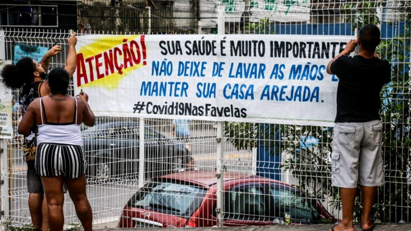 Las entradas principales del Complexo do Alemão (Río de Janeiro), uno de los complejos de favelas más grandes de Brasil, cuentan con pancartas de aviso a los vecinos. COLETIVO PAPO RETO.