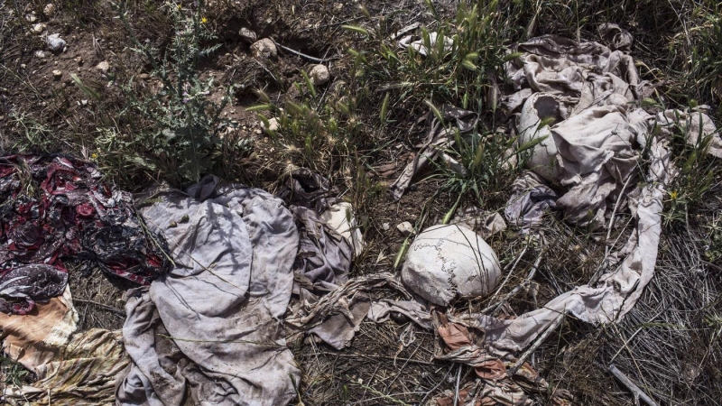 Restos de cráneos humanos y ropa quedan al descubierto en una fosa común en Solakh, al Sur de Sinjar.