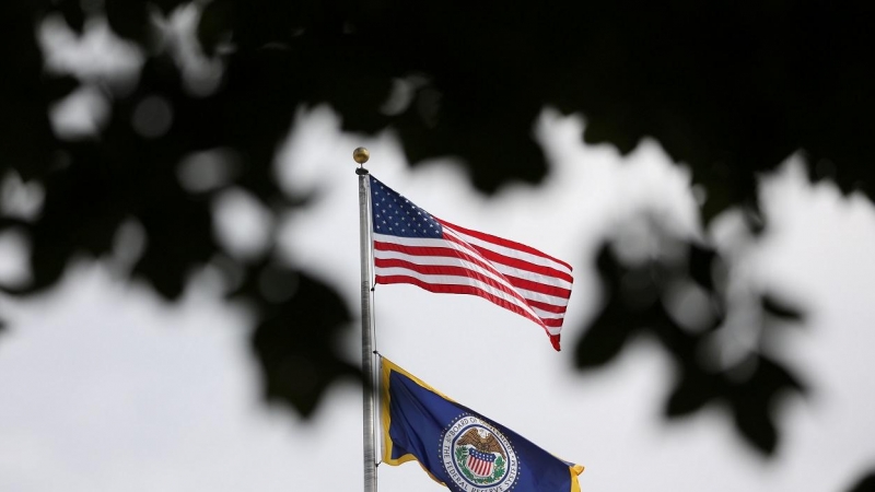 La bandera de EEUU sobre la enseña de la Reserva Federal (Fed) en lo alto de la sede del banco central estadounidense en Washington. REUTERS/Chris Wattie