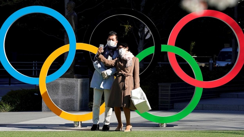 24/03/2020.- Una pareja con mascarillas se hace fotos frente a la sede del Comité Olímpico de Japón en Tokio. / EFE - FRANCK ROBICHON