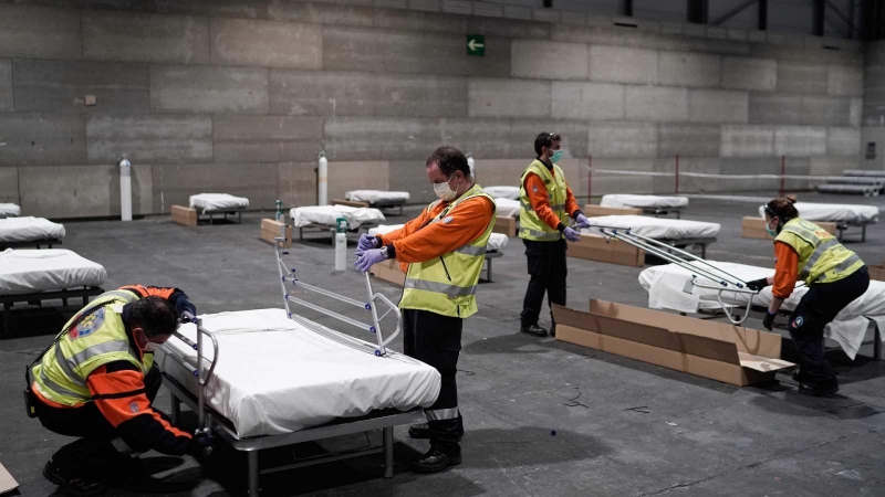 Operarios ayudando a construir el hospital de campaña en el Ifema de Madrid. / EFE