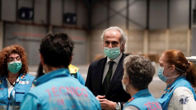El consejero de Sanidad de la Comunidad de Madrid, Enrique Ruiz Escudero, conversa con personal sanitario de IFEMA. EFE
