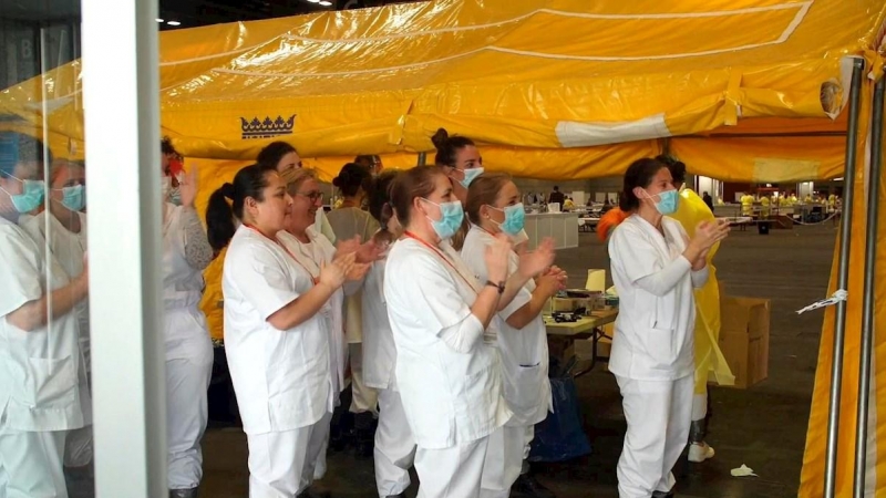 personal sanitario que aplaude este lunes la primera alta a uno de los pacientes atendidos por coronavirus en el  hospital provisional instalado en la Feria de Madrid. EFE