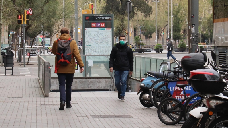 Una persona amb mascareta sortint de la boca de metro de plaça Universitat en plena onada de coronavirus a Barcelona. AINA MARTÍ / ACN