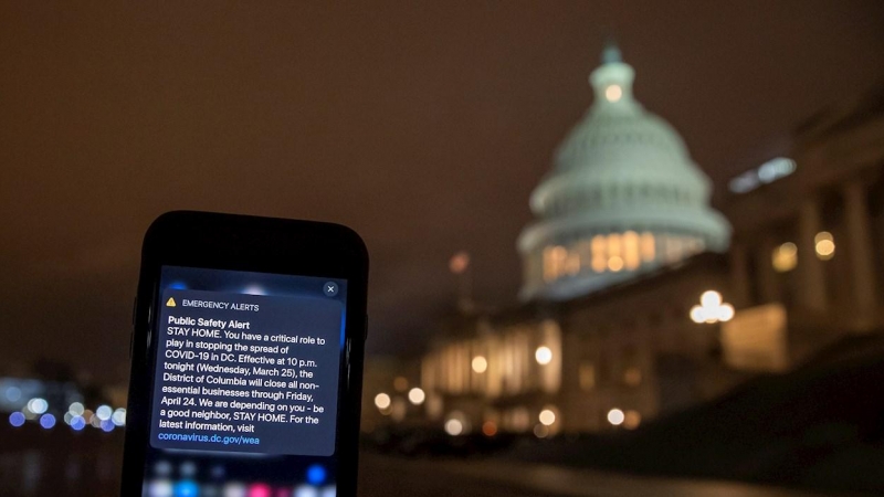 Un mensaje para quedarse en casa llega a un móvil de la ciudad de Washington a las puertas del Capitolio. /EFE