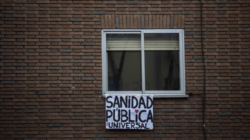 Un cartel en el que pone 'Sanidad pública y universal' cuelga de una ventana durante la cuarentena / JAIRO VARGAS