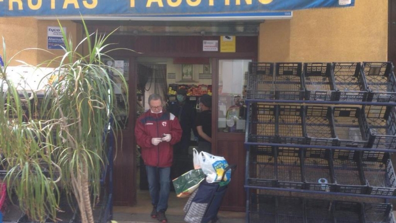 Un cliente sale de una frutería, en Sevilla. Raúl Bocanegra