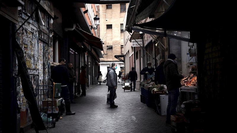 Un hombre espera su turno en una frutería del Mercado de Antón Martín en Madrid. Las colas para comprar en los supermercados se han vuelto parte del paisaje urbano ante el estado de alarma por la pandemia del coronavirus, pero las tiendas de alimentación